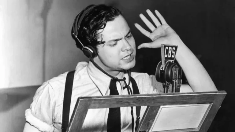 Orson Welles performing at the microphone during the War of the Worlds radio panic
